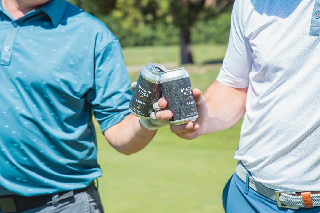 Two golfers drinking a beer on the golf course.